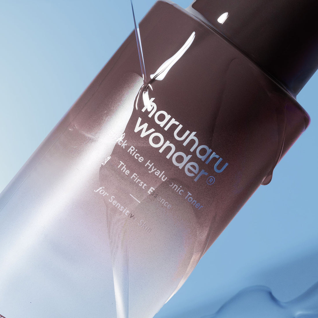 Haruharu Wonder Black Rice Hyaluronic Toner for Sensitive Skin, close-up of the bottle with clear liquid against a blue background