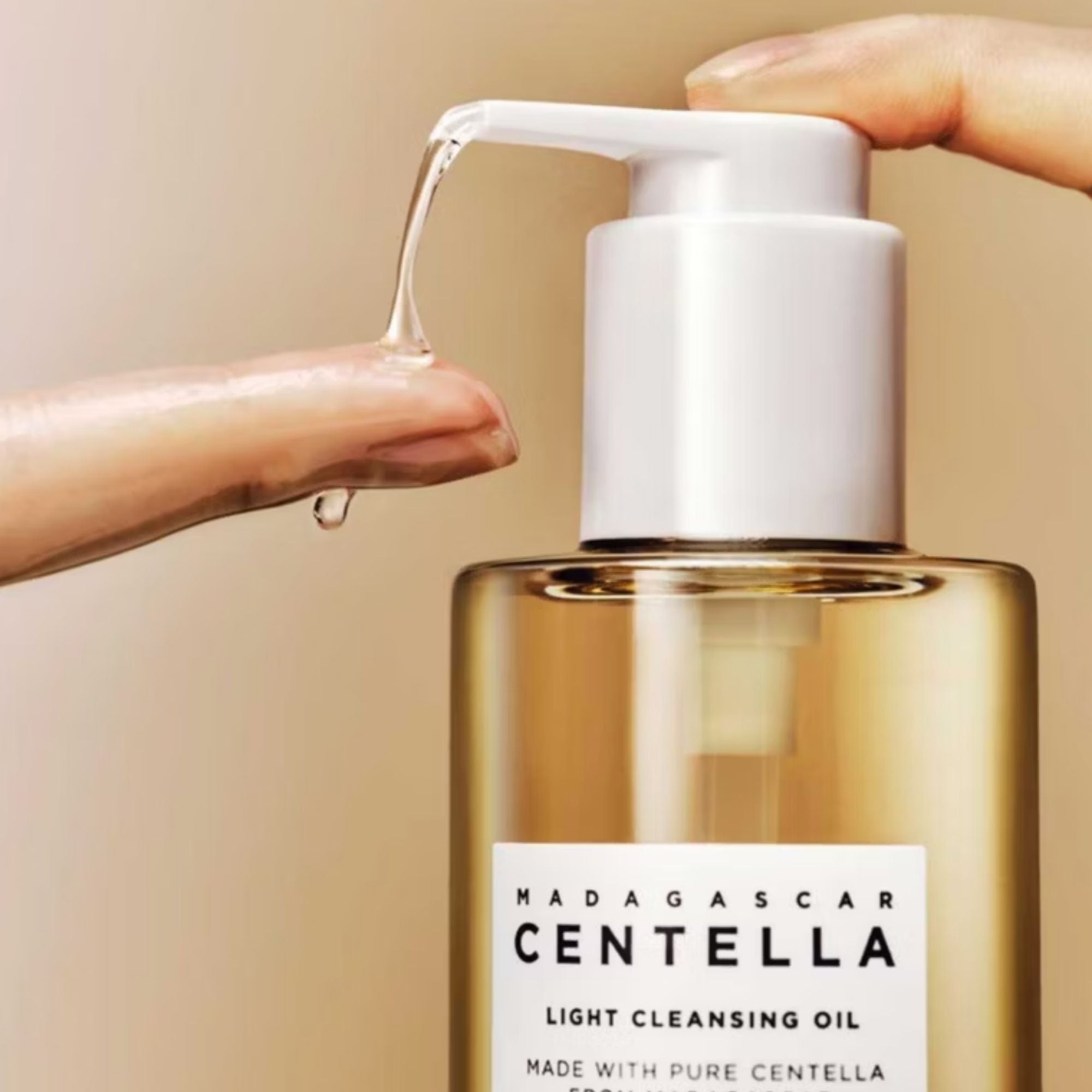 Bottle of Madagascar Centella light cleansing oil with a pump being pressed, showing oil dripping.