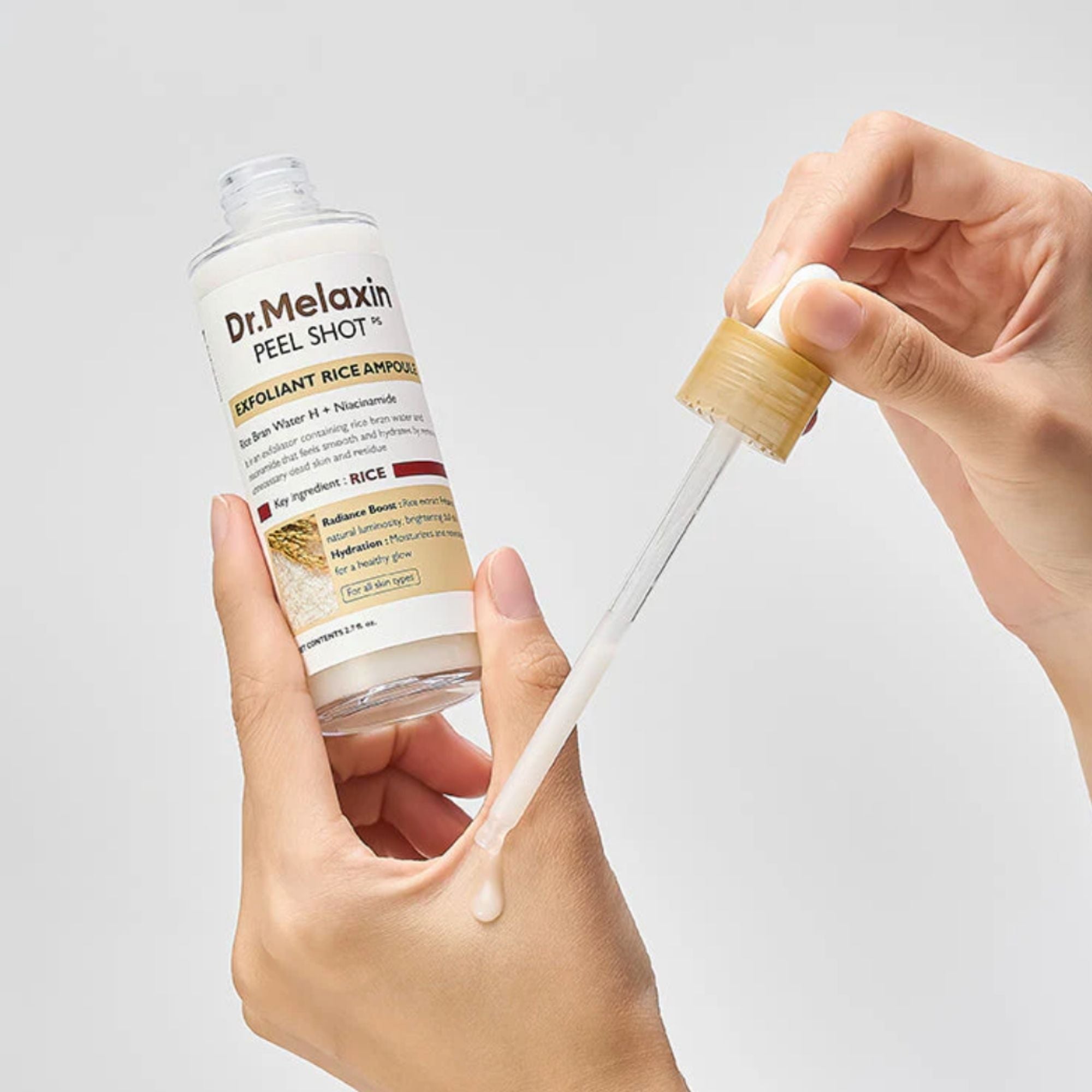 Dr. Melaxin peel shot ampoule with a dropper being held by a hand on a light gray background