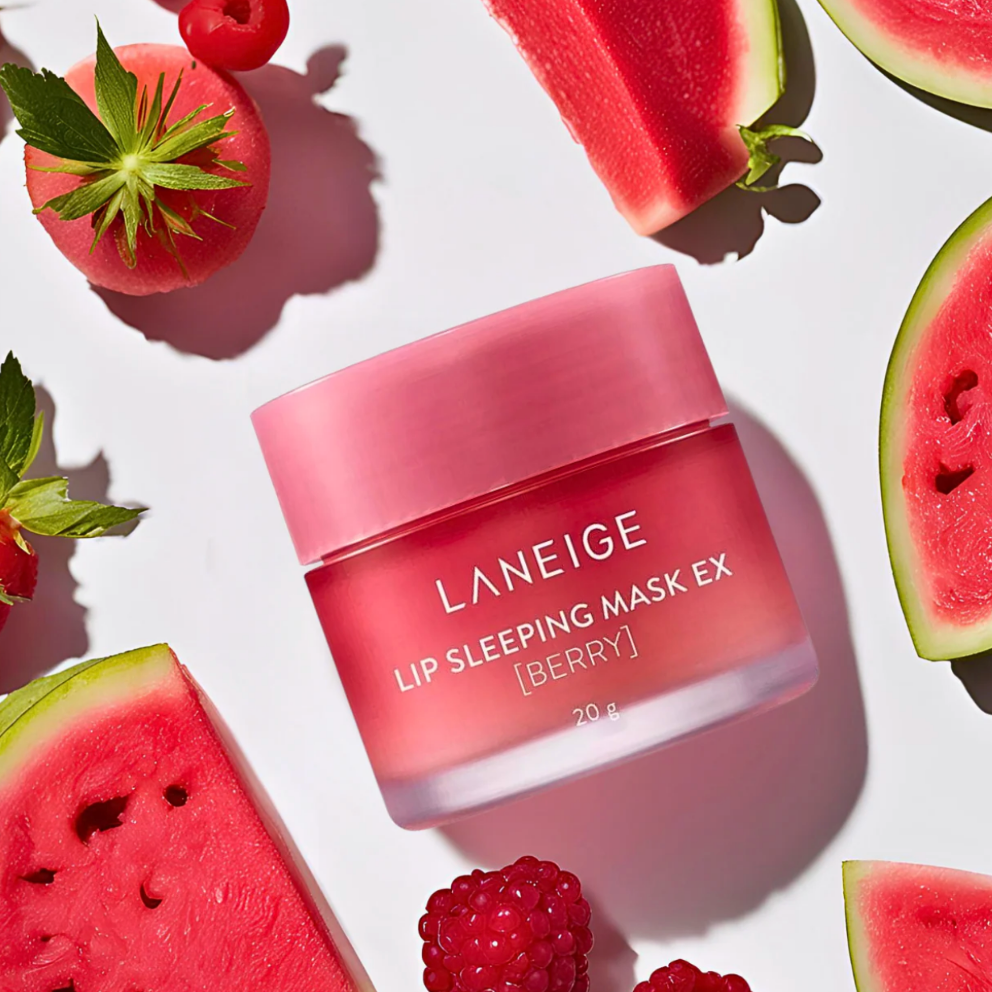 Laneige Lip Sleeping Mask EX Berry jar surrounded by watermelon and raspberries on a white background