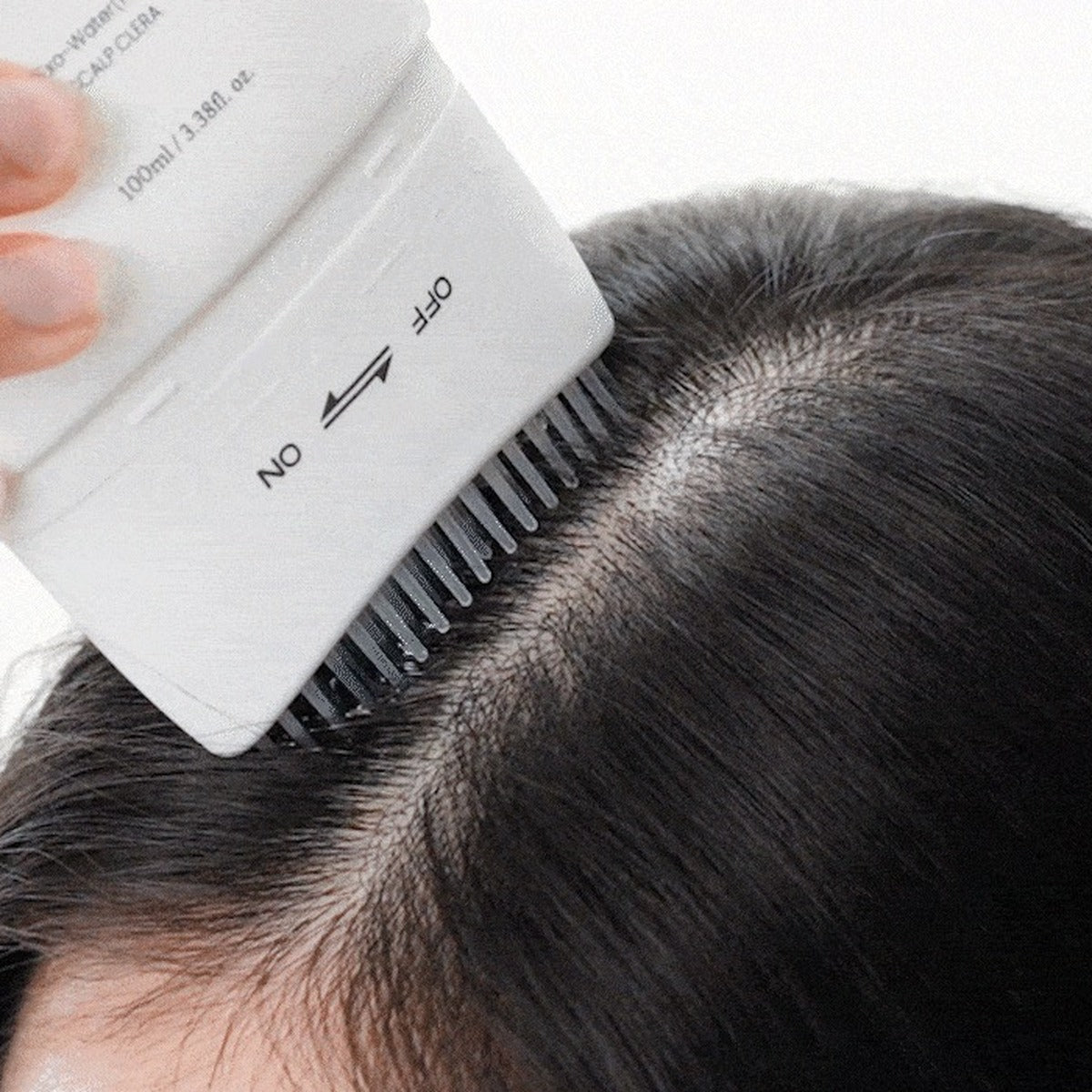 Applying Lilyeve GROW:TURN along the parting with the brush head