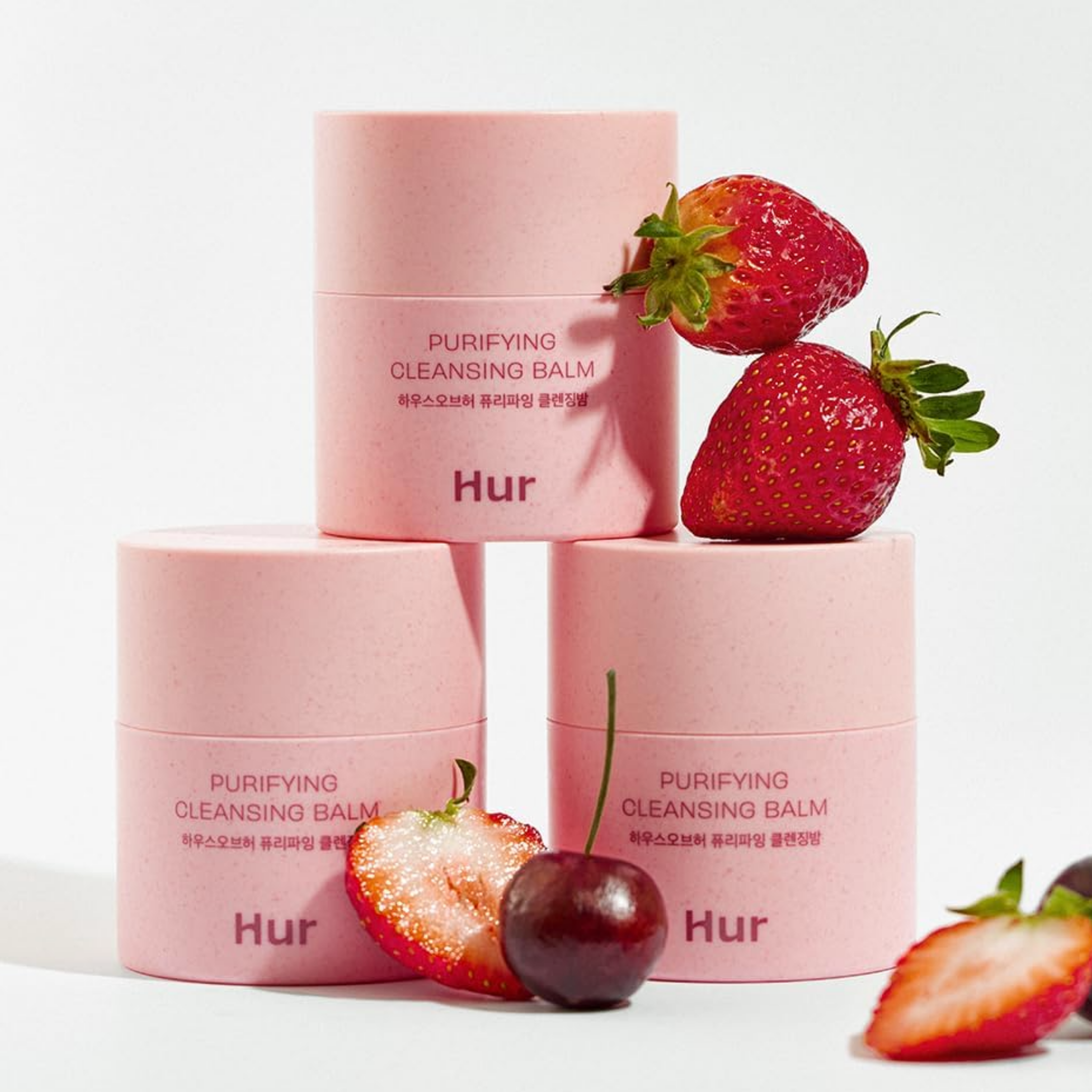 Pink skincare products with strawberries on a white background